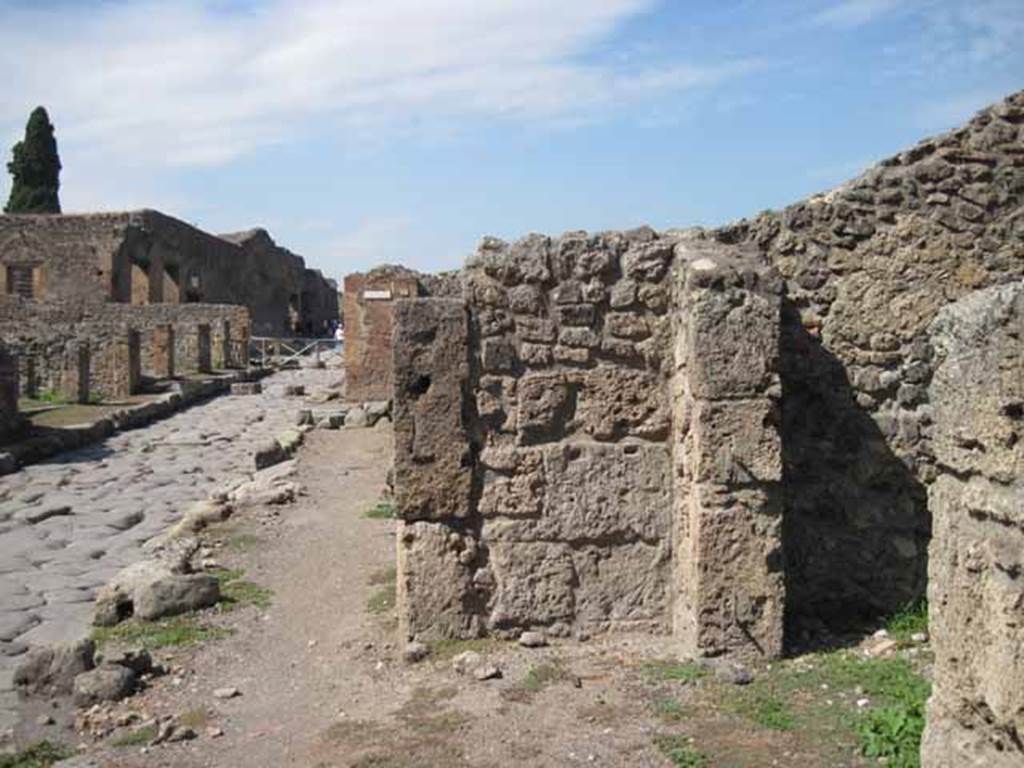 I.1.5 Pompeii. September 2010. Side wall of I.1.6 projecting onto pavement. Site of bench. Looking north along Via Stabiana towards Vicolo del Conciapelle. Photo courtesy of Drew Baker. According to Fiorelli, there was a bench for sitting, near to the entrance doorway. See Pappalardo, U., 2001. La Descrizione di Pompei per Giuseppe Fiorelli (1875). Napoli: Massa Editore. (p.33)