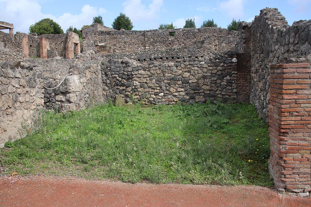 I.1.6 Pompeii. October 2024. 
Looking east across shop-room, with doorway in north wall into I.1.8, on left. Photo courtesy of Klaus Heese.