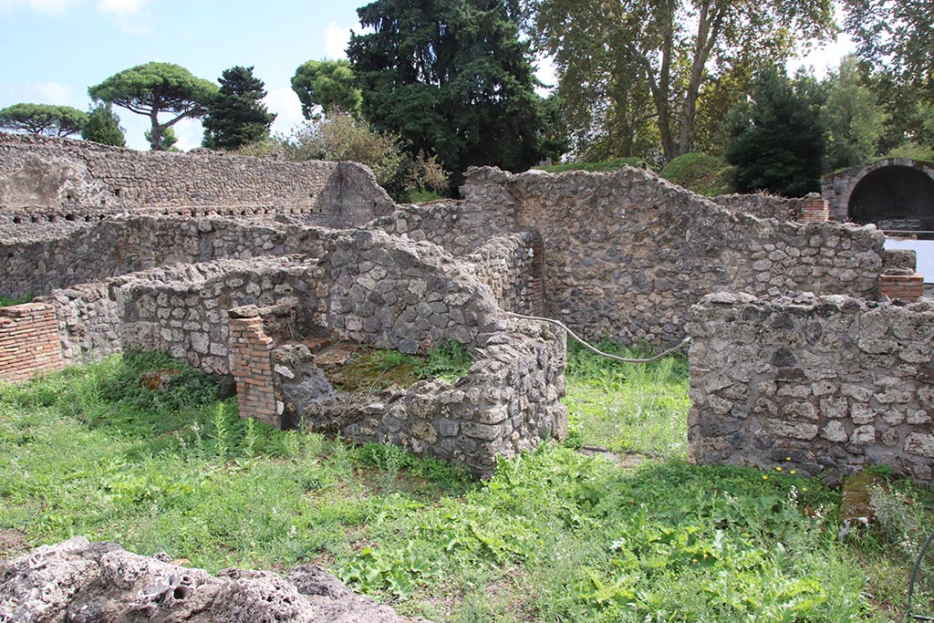 I.1.8 Pompeii. October 2024. 
South wall of entrance room, with hearth, in centre, and doorway leading to I.1.6, on right. Photo courtesy of Klaus Heese.