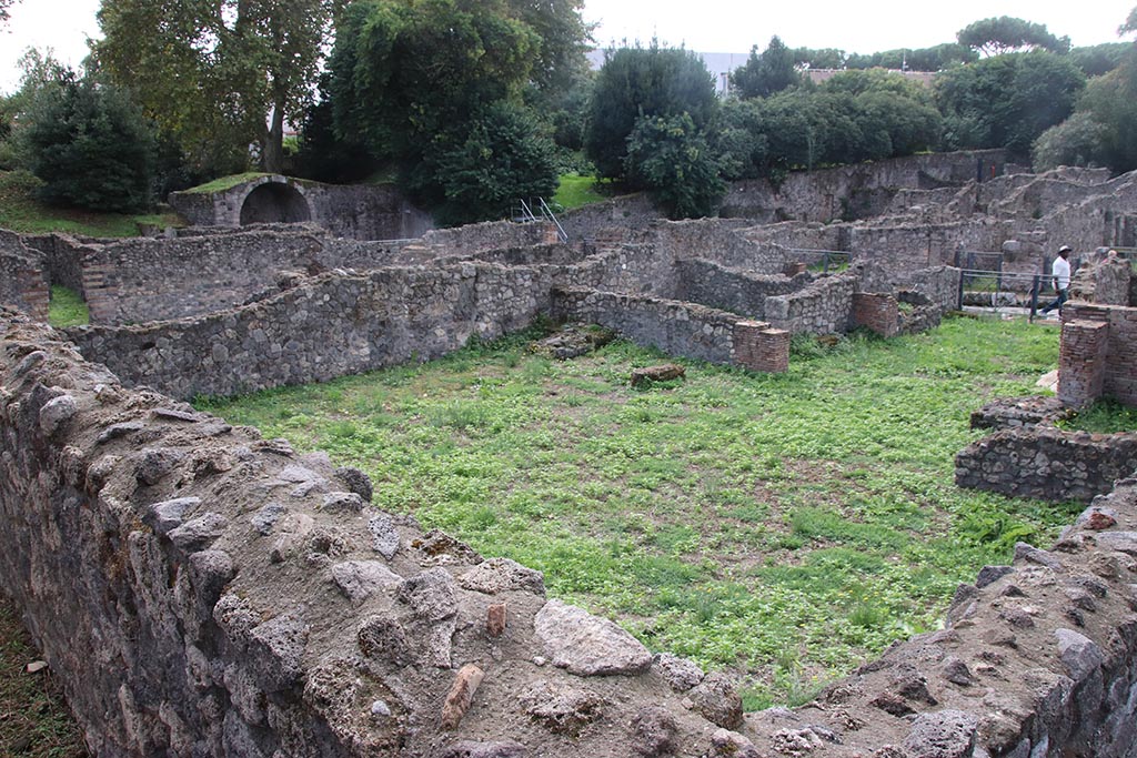 I.1.8 Pompeii. October 2024. 
Rear of hospitium, looking south-west across I.1.8 towards Stabian Gate, from Vicolo del Conciapelle. Photo courtesy of Klaus Heese.