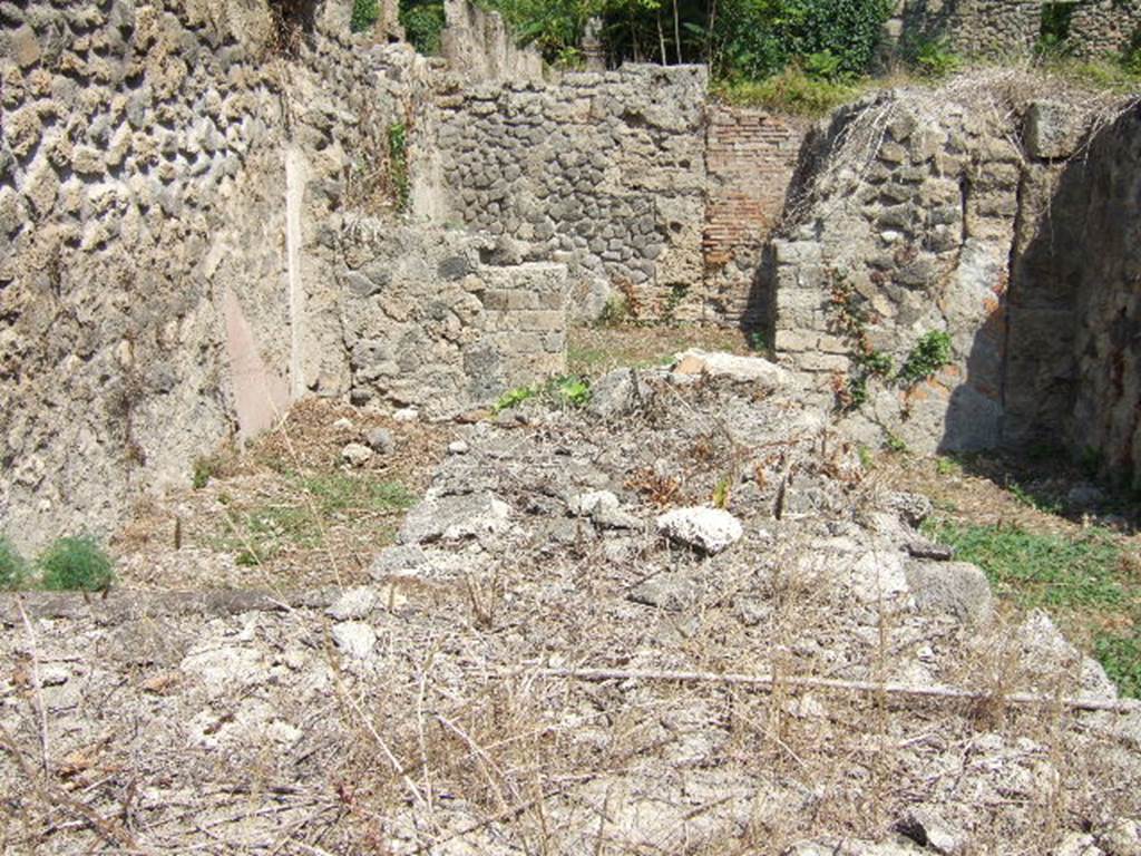 I.1.9 Pompeii. September 2005.  Looking east to rear room.  In front, remains of two-sided counter with hearth and built-in Dolium.