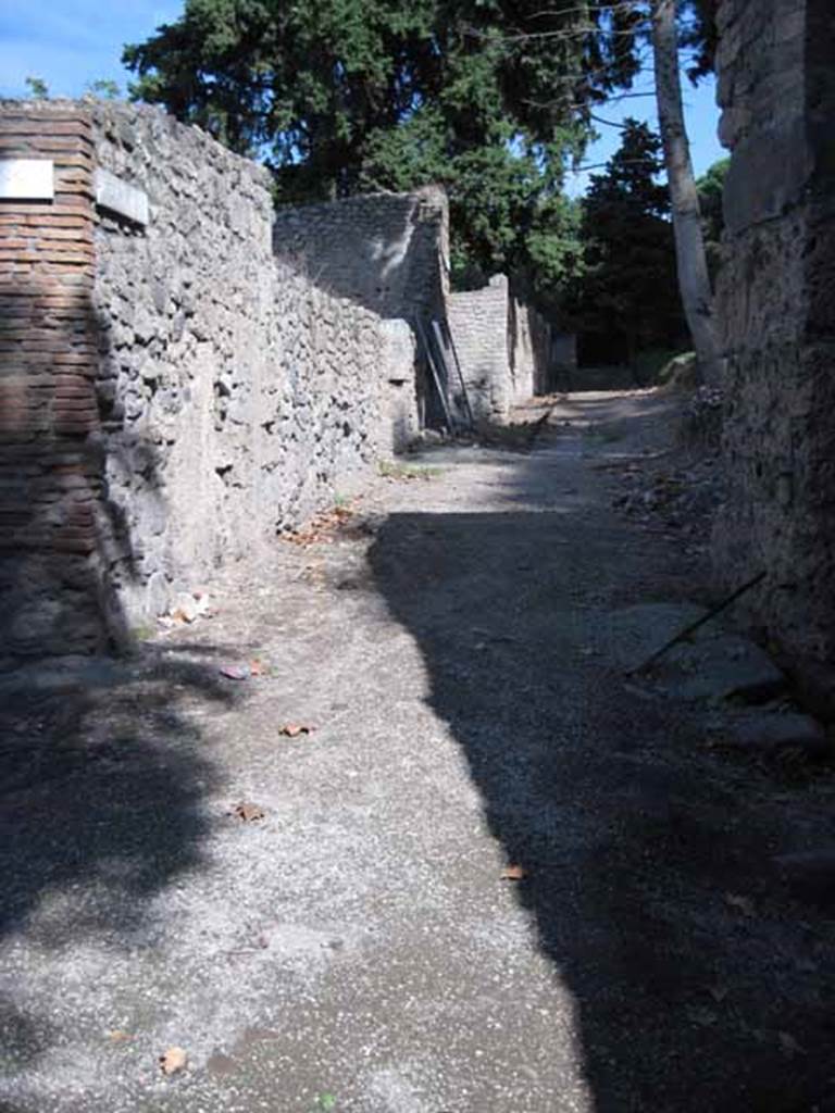 I.1.10 Pompeii. September 2010. Looking east along unnamed vicolo between regio I and city walls. The entrance doorway to I.1.10 is in the left wall. Photo courtesy of Drew Baker.