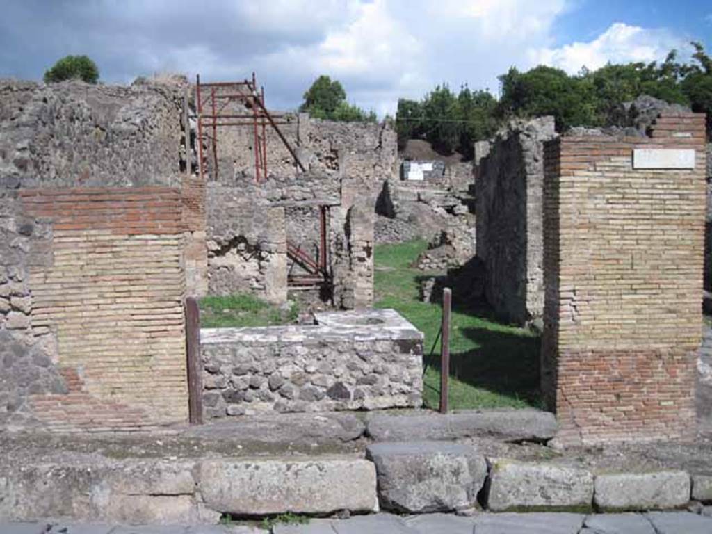 1.2.1 Pompeii. September 2010. Entrance looking east, from Via Stabiana. The side/rear doorway can be seen at I.2.32, on the right. Photo courtesy of Drew Baker.
Warscher described this as –
“I.2.1 una ampia caupona a due porta, poiché risponde anche nel vico a mezzogiorno col vano segnato dal No.32”.
See Warscher T., 1935. Codex Topographicus Pompeianus: Regio I.2.(after photo no.1). Rome:DAIR, whose  copyright it remains.