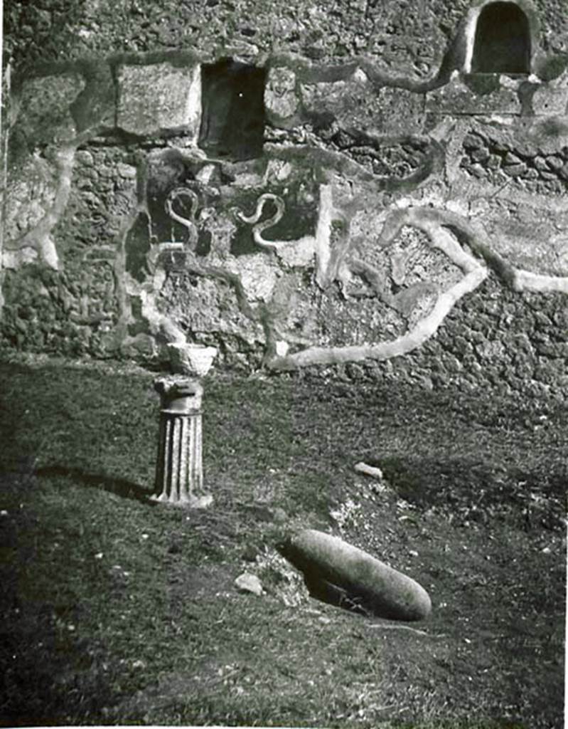 I.2.3 Pompeii. 1935 photo by Tatiana Warscher. Looking south across atrium, with remains of impluvium, and single-legged monopodium. In the south wall the two niches for the household Lares, under which the two serpents in stucco relief can be seen.
See Warscher T., 1935. Codex Topographicus Pompeianus: Regio I.2. (no.2a), Rome: DAIR, whose copyright it remains.
