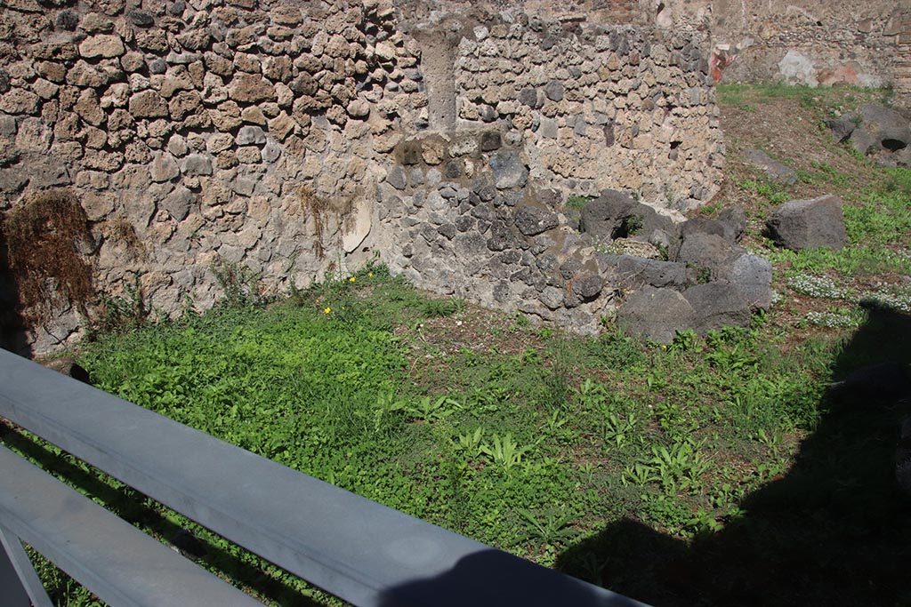 I.2.4 Pompeii. October 2024. 
Looking towards north wall of shop-room, with north-west corner of atrium of I.2.3, behind low ruined wall. Photo courtesy of Klaus Heese.