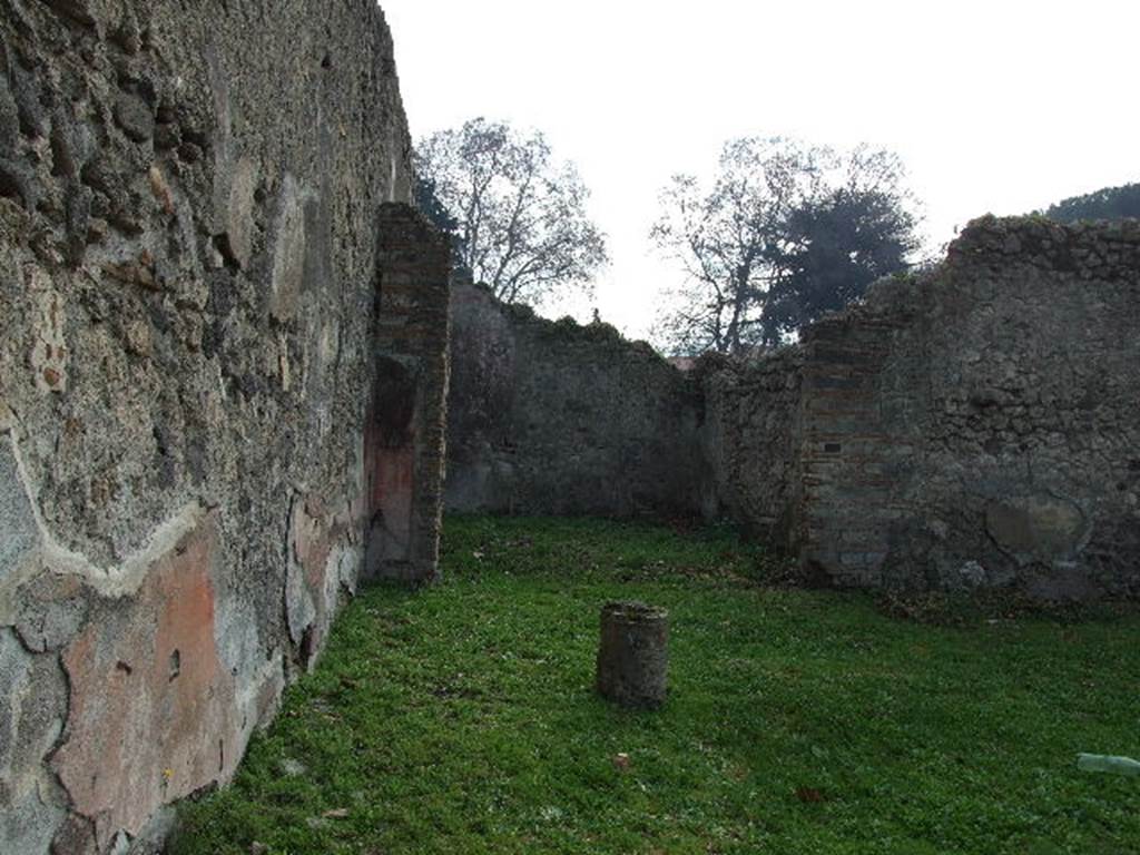 I.2.6 Pompeii.  December 2006. East wall of peristyle, looking south to triclinium.
Traces of original plaster can still be seen on the east wall of the peristyle. 
When excavated this could be seen as painted in red and divided in compartments by gold coloured candelabra.  
Photographs by Tatiana Warscher of this area can be seen in - Garcia y Garcia, L., 2006. Danni di guerra a Pompei. Rome: L’Erma di Bretschneider. (p. 39)
When excavated the triclinium had 3 large paintings. 
However, one fell together with its wall, another which showed Meleager at the hunt of the Calydonian boar remained slightly visible on the east wall (now faded) and the one most intact was sent to Naples Archaeological Museum, (NAP inventory number 109751, The theft of the Palladium), at the side of which were two medallions showing female busts crowned with foliage of vine leaves and herbs. 
These were found on the south wall. 
A medallion of a young person crowned with vine foliage was found on the south wall.
See Pappalardo, U., 2001. La Descrizione di Pompei per Giuseppe Fiorelli (1875). Napoli: Massa Editore. (p.35)