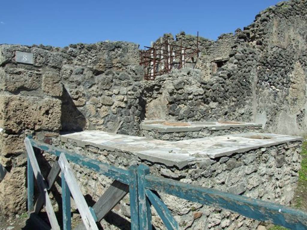 I.2.8 Pompeii. March 2009. L-shaped serving counter and entrance.
According to Fiorelli, the L-shaped counter would have had two urns and a hearth, and not one urn, as now seen. See Pappalardo, U., 2001. La Descrizione di Pompei per Giuseppe Fiorelli (1875). Napoli: Massa Editore. (p. 35)  See Van der Poel, H. B., 1986. Corpus Topographicum Pompeianum, Part IIIA. Austin: University of Texas. (p.4)