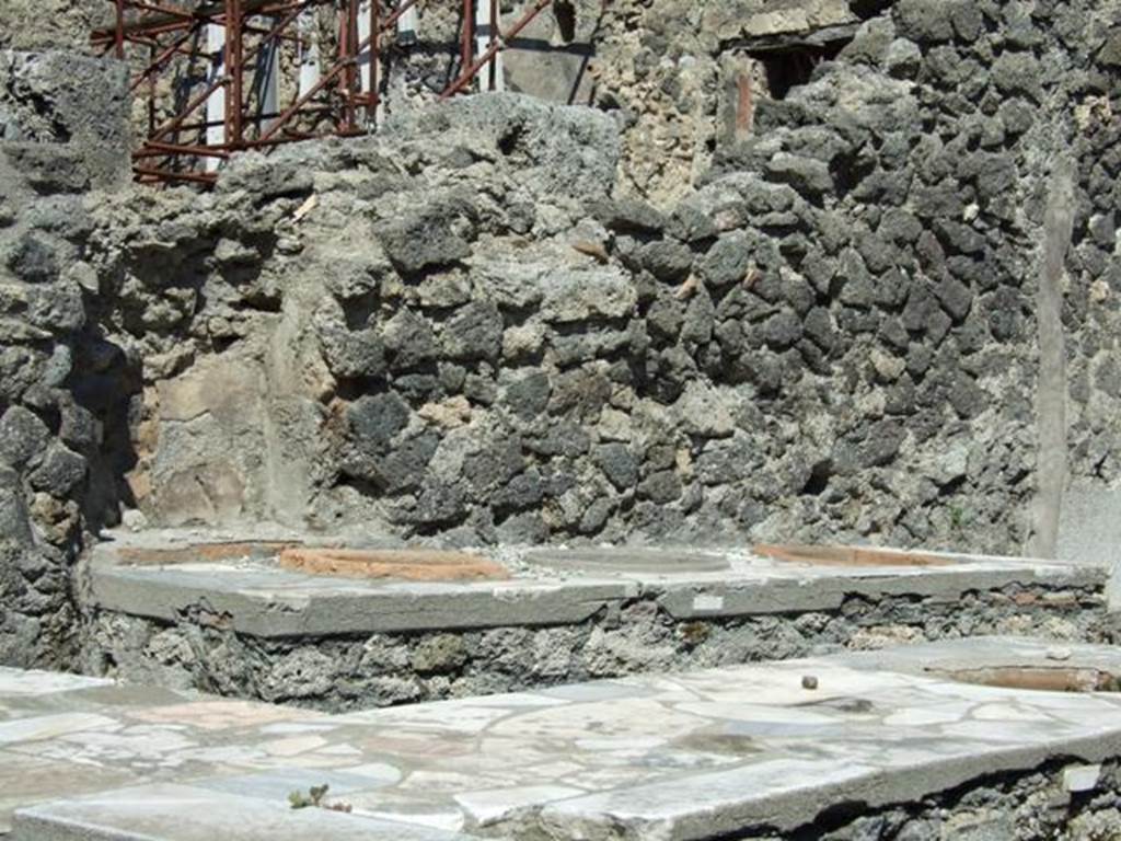 I.2.8 Pompeii. March 2009. North wall with niche behind additional counter with three urns, and L-shaped serving counter in the front.