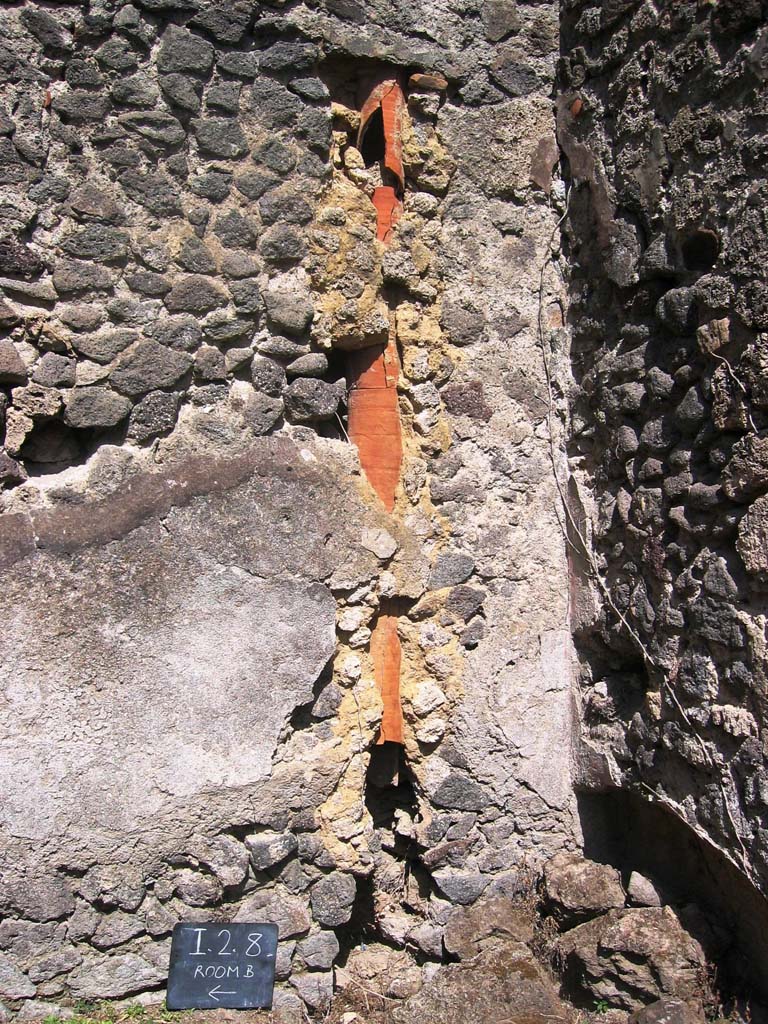 I.2.8 Pompeii. July 2008. 
Down-pipe in east wall near south-east corner of rear room. Photo courtesy of Barry Hobson.
