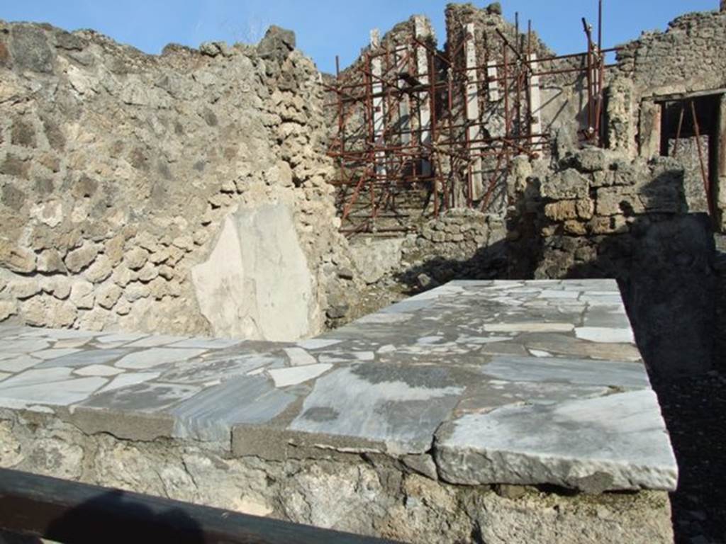 I.2.11 Pompeii. December 2007. Looking east across counter, north wall and towards small rear room.