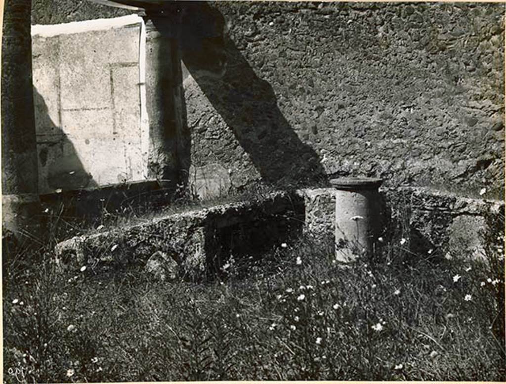 I.2.28 Pompeii. 1931. Looking west towards triclinium. See Warscher T., 1935. Codex Topographicus Pompeianus: Regio I.2. (no.54), Rome: DAIR, whose copyright it remains.
(According to Warscher, No.54, Triclinio nella parte occidentale del pseudo-peristilio (h). 
La negative appartiene all’Istituto Arch. Germ. 1931; 2853.) Warscher wrote, quoting Bull. Inst.1874, p.251/52, that – “Il triclinio murato sta appoggiato al muro occidentale del peristilio, dimodochè verso la sera non vi poteva arrivare il sole, e, come quei ritrovati prima, è più alto verso la tavola, il cui posto è segnato da un sostegno rotondo, ove senza dubbio mettevasi la tavola di legno colle vivande. Più lungo degli altri è il letto a sinistra di chi sta avanti al triclinio, perchè a tavola si appoggiavano sul braccio sinistro, stendendo a destra la parte inferiore del corpo. Precisamente lo stesso si osserva nel triclinio della casa di Sallustio. Dalla parte interna di ciascuno dei letti sono quattro piccole nicchie, alte m. 0,24, larghe 0,19, profondo 0,20, più grande l’ultima del letto più lungo, separata dalle altre da una apertura del pozzo. Al triclinio si accedeva per un scalino alla estremità del letto settentrionale, dimodochè per arrivare al suo posto ciascuno doveva passare dietro ai posti degli altri. Ecco le misure del triclinio: letto meridionale, lunghezza esterna m.3,75, interna 2,35, larghezza 1,30; lunghezza interna del letto occidentale 1,37; letto settentrionale, lunghezza interna 1,30, esterna circa 2,50, larghezza 1,50. –
Aggiungo ancora che accanto allo scalino è un piccolo rialzo di materiale, che poteva servire di tavola, e che accanto all’estremità del letto più lungo sta un’ara fi tuffo, tonda, più grossa nella parte inferiore, con margine sporgente di sopra e di sotto, - finalmente che nel sostegno della tavola dalla parte di S si è fatto una specie di taglio verticale e piuttosto profondo, che non arriva fino alla superficie e di cui non ho saputo indovinare lo scopo”.