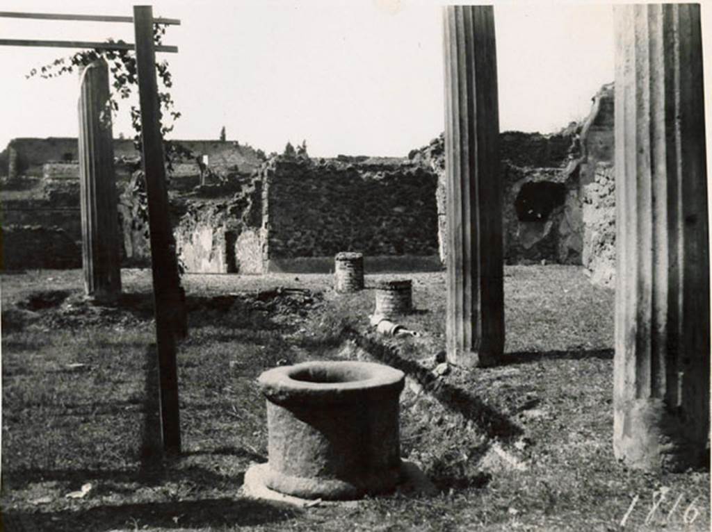 I.3.3 Pompeii. 1935 photograph taken by Tatiana Warscher from the north-east corner of the peristyle. To the right, the north portico with a pipe from the acqueduct. The pipe was also found along the west portico. The remains of the pipe of the acqueduct could be seen in both the north and west portico.  In the north-west corner, on the right, the recess for the triclinium couch can be seen. The house can be found opposite the theatres.
See Warscher, T, 1935: Codex Topographicus Pompejanus, Regio I, 3: (no.10a), Rome, DAIR, whose copyright it remains.  
According to Jashemski, quoting Mau, there were two cistern openings, one in the north-east corner of the garden, with a tufa puteal, the other opening in the corresponding corner of the portico. Water emptied at the north-east corner from the gutter into the cistern and into the street at the south-east and south-west corners. Between the gutter and the portico there was an aqueduct pipe which came out of the first column, counting from the south, on the west portico.  Supporting itself on the second column on the west side, the pipe rose to give a jet of water in the gutter. Flanking the west portico and the one to the north, it disappeared towards the north-east. Twice, on the west side, by a widening of the pipe, it was possible to let water flow into the gutter. 
The gutter at precisely these two points had openings towards the garden which the apparatus served to water. Before and after the widening of the pipe, it could be closed by a key.  Two branches of this pipe entered the room in the Subterannean Level in which there was a tank, off the north-west corner of the peristyle.
See Mau, BdI, 1874, pp.181-182.
See Jashemski, W. F., 1993. The Gardens of Pompeii, Volume II: Appendices. New York: Caratzas, (p.26).