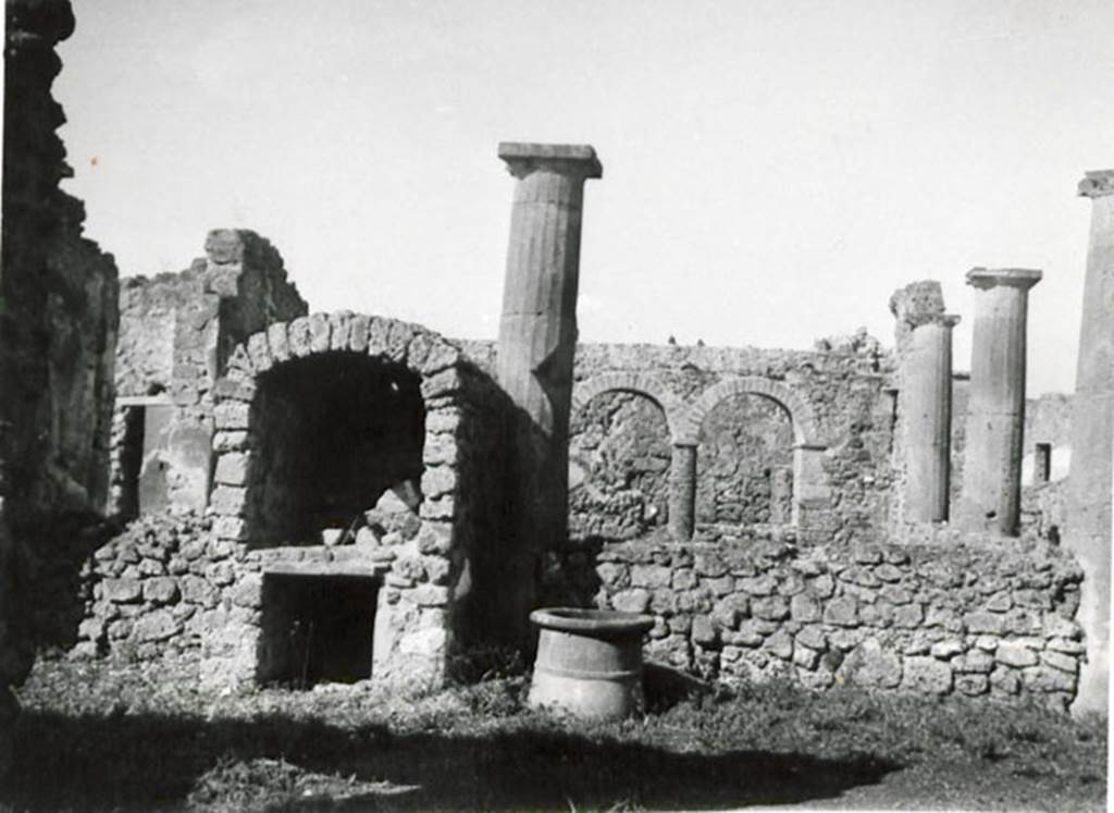 I.3.8b Pompeii. 1935 photograph taken by Tatiana Warscher, taken from the east. 
See Warscher, T, 1935: Codex Topographicus Pompejanus, Regio I, 3: (no.16a), Rome, DAIR, whose copyright it remains.  
According to Warscher, 
“This house was not without interest. The tufa Doric columns of the peristyle had been joined – later – by a wall between them. The west side of the portico consisted of brick columns surmounted by arches. Above these arches was a walkway. The north wall ended in a vault.”