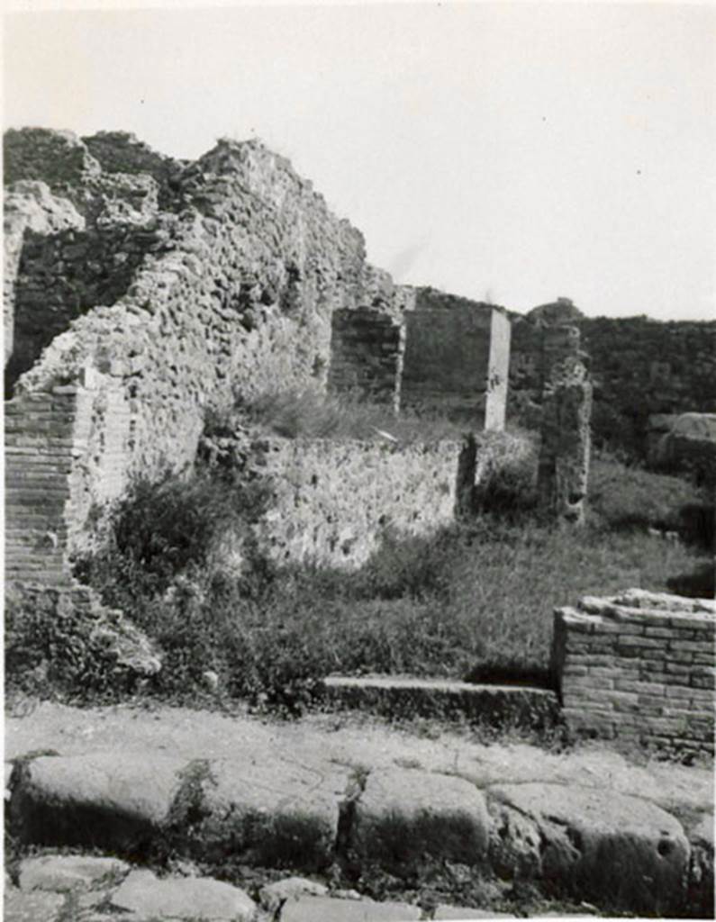 I.3.10 Pompeii. 1935 photograph taken by Tatiana Warscher, looking east towards entrance from Via Stabiana. 
See Warscher, T, 1935: Codex Topographicus Pompejanus, Regio I, 3: (no.26), Rome, DAIR, whose copyright it remains.  
According to Warcher, “This was a workshop with other rooms, altered from the ancient configuration by the route of the Sarno canal built by Fontana: here one can see the remains of wash-tubs and furnaces that existed here before”.