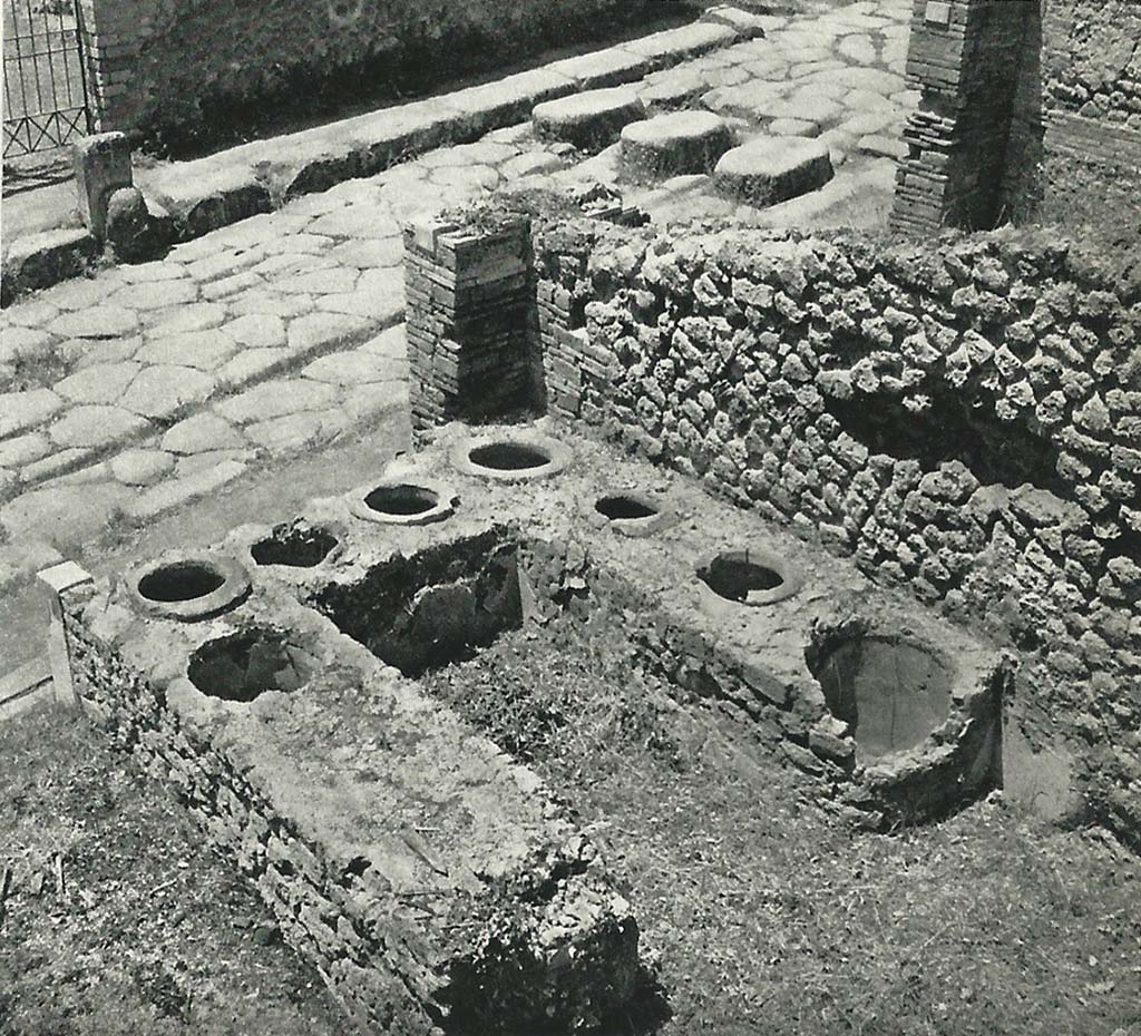I.3.11 Pompeii. Old undated photograph. Looking west across top of counter towards Via Stabiana.
On the opposite side of the road is the entrance to VIII.7.25, and the fountain outside the doorway.