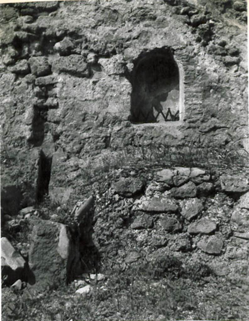 I.3.15 Pompeii. 1935 photograph taken by Tatiana Warscher. Looking towards arched niche in west wall.
See Warscher, T, 1935: Codex Topographicus Pompejanus, Regio I, 3: (no.31), Rome, DAIR, whose copyright it remains.  
According to Warcher, quoting Fiorelli, “On the right of this workshop were the first steps of the stairs that went up to the upper floor, under which was a podium, with furnace in the middle to accommodate a large boiler, which was used as a laundry. Embedded in nthe wall was the niche for the Lares”.