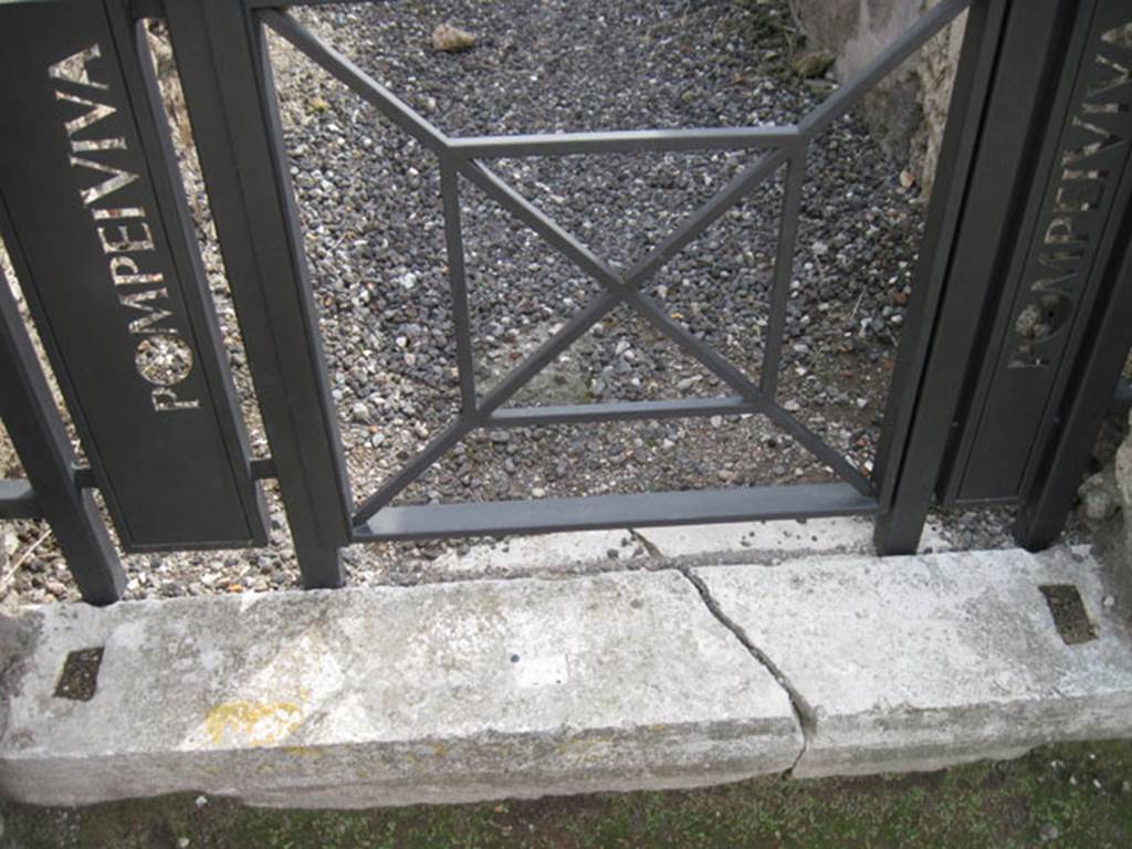I.3.20 Pompeii. September 2010. 
Looking south to detail of marble entrance threshold block, showing doorpost slots. 
Photo courtesy of Drew Baker.
