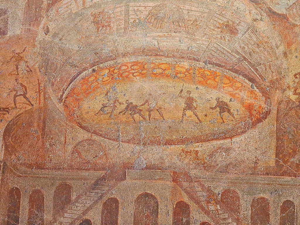 I.3.23 Pompeii. Photo taken May 2021, courtesy of Giuseppe Ciaramella. Rear wall of the peristyle. 
Detail of fighting inside the amphitheatre, from painting Riot in the Amphitheatre. 
Now in Naples Archaeological Museum. Inventory number 112222.