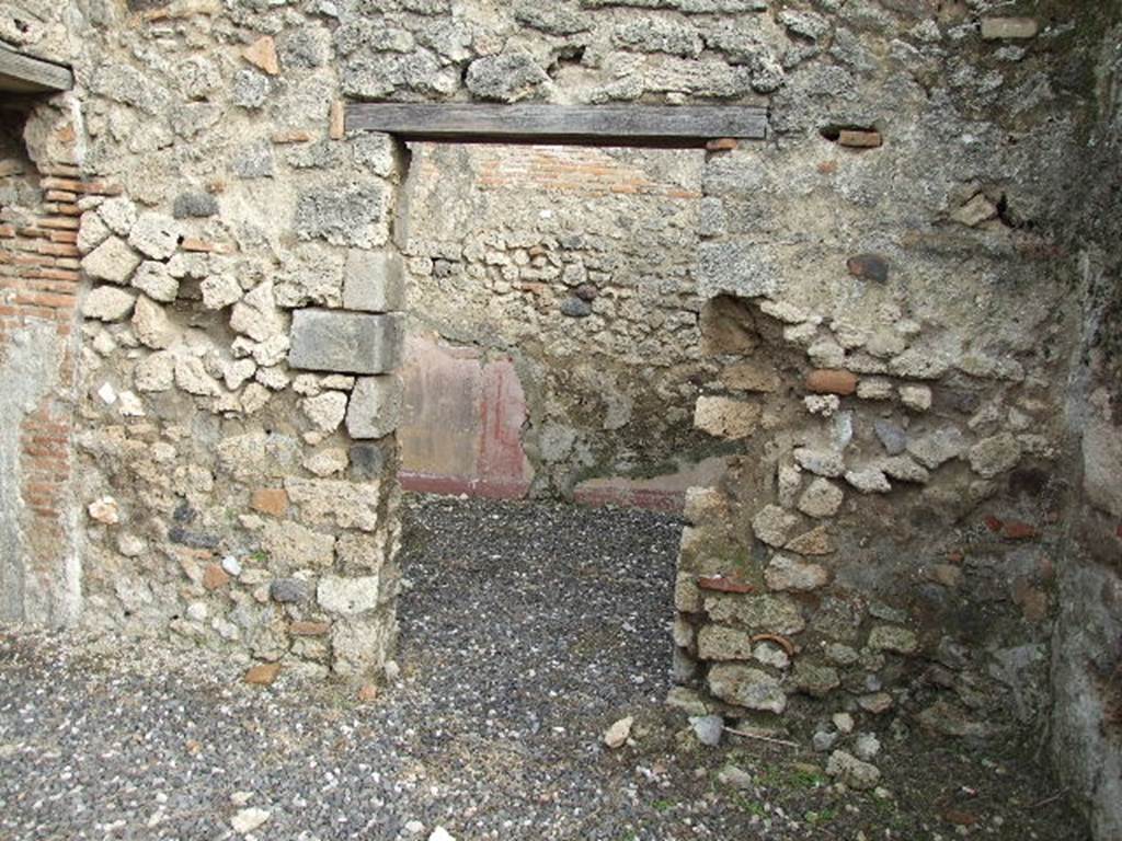 I.3.24 Pompeii. December 2006. Doorway to cubiculum on east side of peristyle.
According to Fiorelli, the wall painting of a lion, hind, dog and hare found in the corner of the walkway, was found next to this doorway. See Pappalardo, U., 2001. La Descrizione di Pompei per Giuseppe Fiorelli (1875). Napoli: Massa Editore, (p.40)
According to Bull. Inst. –  “In un altro angolo del peristilio è dipinto, nella maniera grossolana delle pitture topiarie, un leone che dilania una cerva e più sotto un cane che addenta una lepre”. (translation: "Found painted in a coarse manner in another corner of the peristyle was a lion tearing apart a hind and beneath a dog biting a hare".) See BdI, 1869, p.239-240.