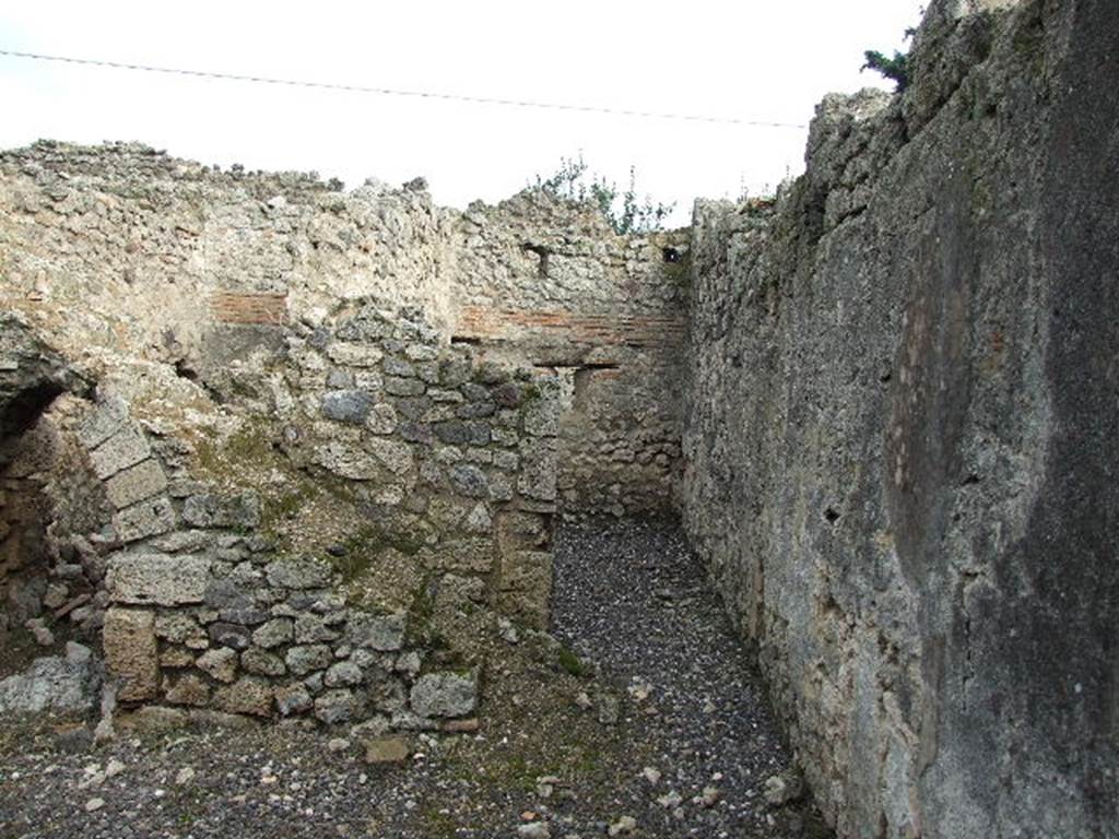 I.3.24 Pompeii. December 2006. Steps to upper floor, kitchen doorway and rear, south wall of house. According to Boyce, on this south wall of the peristyle was the Lararium painting. He described - The Genius, holding cornucopia against his left shoulder, poured a libation upon an altar from a patera held in his right.  Beside him stood a Camillus holding a shallow dish.  Opposite the Genius were the tibicen and the popa, the latter leading a pig to sacrifice. Only the Lar on the right remained.
In the lower zone, a single red and yellow serpent coiled towards an altar. Nothing now remains of this painting in situ.
See Boyce G. K., 1937. Corpus of the Lararia of Pompeii. Rome: MAAR 14. (p. 24)