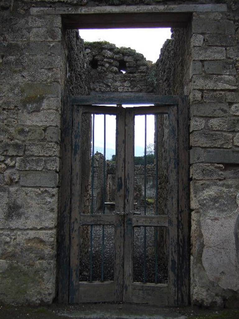 I.3.24 Pompeii. December 2005. Entrance doorway. According to Garcia y Garcia, a plaster cast of a portion of the entrance doorway with two shutters (leafs), half closed, with lock, door-bolt, hinge and iron doorlock, and provenanced from the doorway at I.3.24, used to be seen in the Antiquarium prior to the 1943 bombing.
See Garcia y Garcia, L., 2006. Danni di guerra a Pompei. Rome: L’Erma di Bretschneider, (p.184, fig.427).