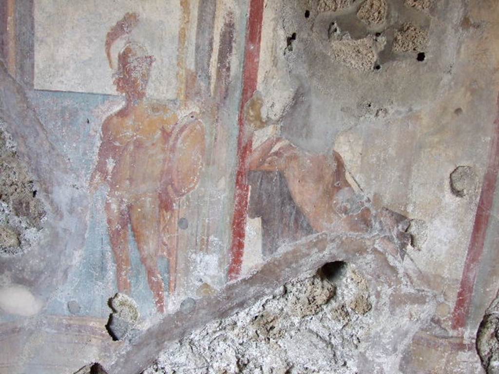 I.3.25 Pompeii. December 2006. Oecus, east wall. 
Detail of wall painting of Apollo in judgement. His right arm rested on a chair and was supporting his head in thought. 
A warrior to the left symbolised beauty.
Kuivalainen believes the figure on the right (head and feet destroyed) to be Bacchus.
See Kuivalainen, I., 2021. The Portrayal of Pompeian Bacchus. Commentationes Humanarum Litterarum 140. Helsinki: Finnish Society of Sciences and Letters, (p.104, B18).