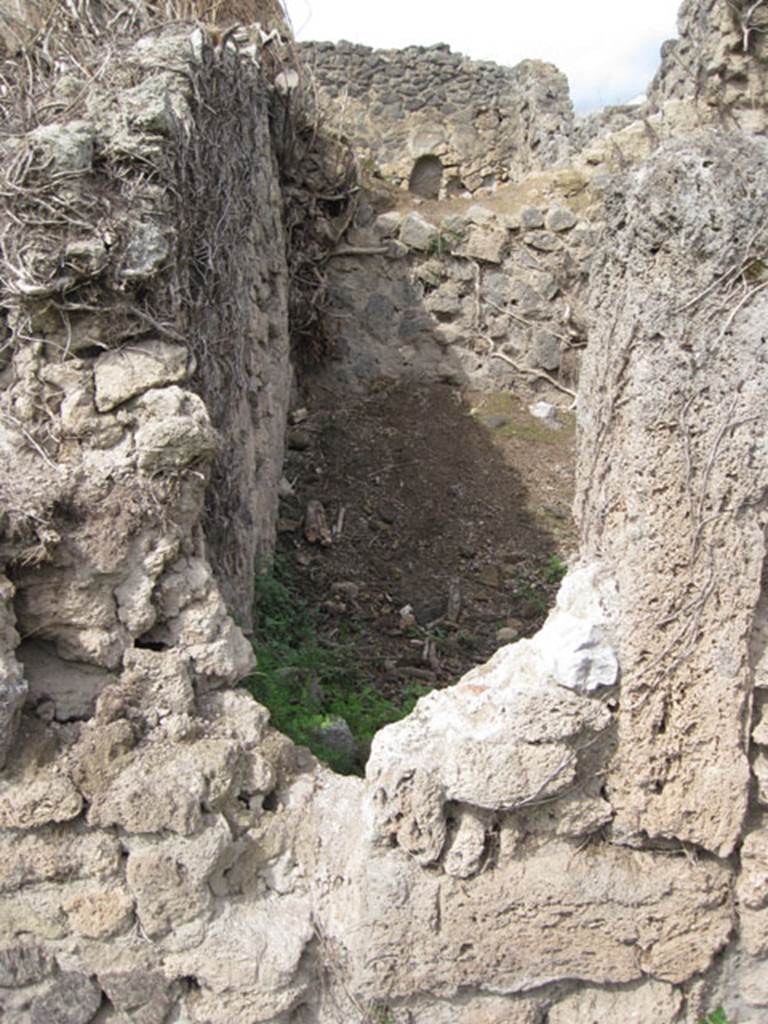 I.3.27 Pompeii. September 2010. Looking north from I.3.3 towards reverse of south-west corner of the above room.  Drew Baker says – the photo was taken to compare form of the aperture. 
The eastern side appears to have a tufa framing member and the base at least a partial threshold however there is no corresponding part on the western side which I would expect. However there is a wall there so it may not have been necessary but as there is what appears to be original fill either this is a door which was blocked up at some point or it is a feature of construction (opus africanum perhaps). 
Photo courtesy of Drew Baker.
