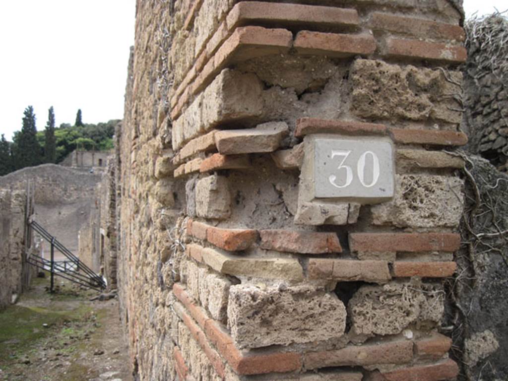 I.3.30 Pompeii. September 2010. ID number plate on west side of entrance doorway.
Photo courtesy of Drew Baker. Looking west along unnamed vicolo towards Via Stabiana. Fiorelli called this vicolo “via secunda”.  See Pappalardo, U., 2001. La Descrizione di Pompei per Giuseppe Fiorelli (1875). Napoli: Massa Editore. (p.41)