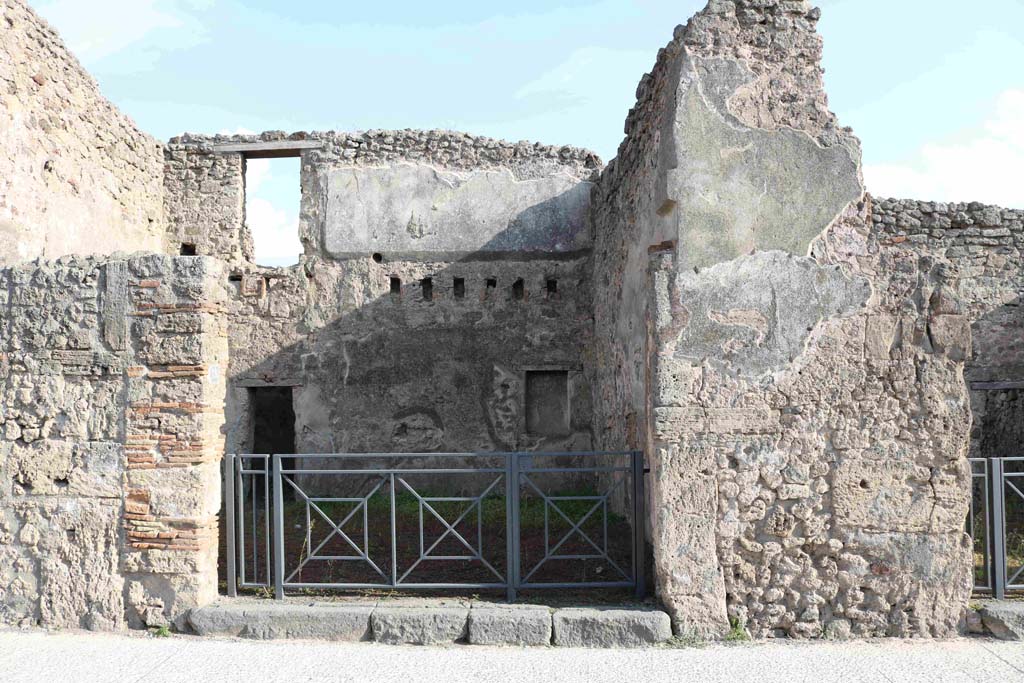 I.4.18 Pompeii. September 2018. Looking south on Via dell’Abbondanza towards entrance. Photo courtesy of Aude Durand.
Della Corte thought this would be the shop and dwelling of the Sabinus that had acclaimed his neighbour M. Epidio Sabino, on the right pilaster of I.4.17:
Sabinus dissignator cum plausu facit (part of CIL IV 768, see I.4.17).
See Della Corte, M., 1965.  Case ed Abitanti di Pompei. Napoli: Fausto Fiorentino, p. 255.