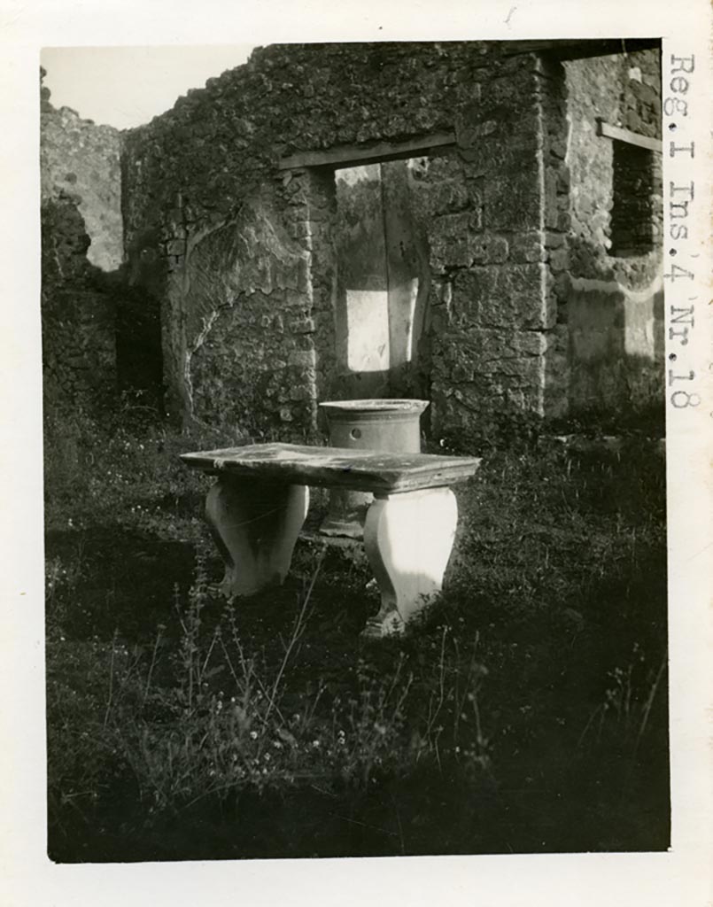 I.4.22 Pompeii but shown as I.4.18 on photo. Pre-1937-39. 
Looking east across atrium with table and puteal towards room “f” with doorway, and room “g”. 
Photo courtesy of American Academy in Rome, Photographic Archive. Warsher collection no. 1515.