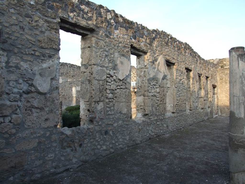 I.4.25 Pompeii. December 2007. 
Looking north-east along the north wall of the lower peristyle 32, with windows to the middle peristyle 17.
Photographed from outside room 36.