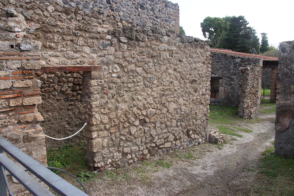 I.5.2 Pompeii. October 2024. 
East wall of shop-room, with doorway leading to a small area beneath the stairway. Photo courtesy of Klaus Heese.