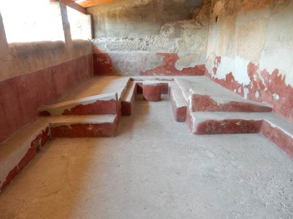 I.6.2 Pompeii. May 2016. Triclinium with table, against the west wall of the loggia.  
The circular table, the couches and the benches, were all painted with motifs of plants and birds on a red background.
Photo courtesy of Buzz Ferebee.