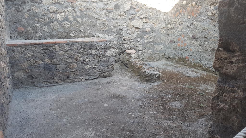 I.6.4 Pompeii. August 2023. 
Room 8, looking through doorway towards east wall with hearth, on left, and latrine, on right. Photo courtesy of Maribel Velasco.