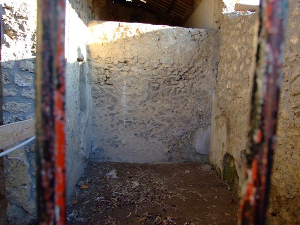 I.6.4 Pompeii. March 2009. Room 12, on the left (east side) is the doorway into room 11.
Ahead is the south wall of room 12, at the rear of this is the small cubiculum with a mosaic floor. 
The small cubiculum has not been photographed.
According to Kuivalainen in an alcove in the east wall of the small cubiculum, he describes – 
“A composition of two figures painted with white on a red background. On the left, a half reclining robed female figure with her head inclining towards her right shoulder. The youth on the right side advances energetically, stepping with his left leg over the female’s legs, with a pedum in his left hand.”
Kuivalainen comments –
“Bacchus, with a pedum in hand, approaching a sleeping Ariadne would be a rare subject. ……………………….”
See Kuivalainen, I., 2021. The Portrayal of Pompeian Bacchus. Commentationes Humanarum Litterarum 140. Helsinki: Finnish Society of Sciences and Letters, (p.144, E4).