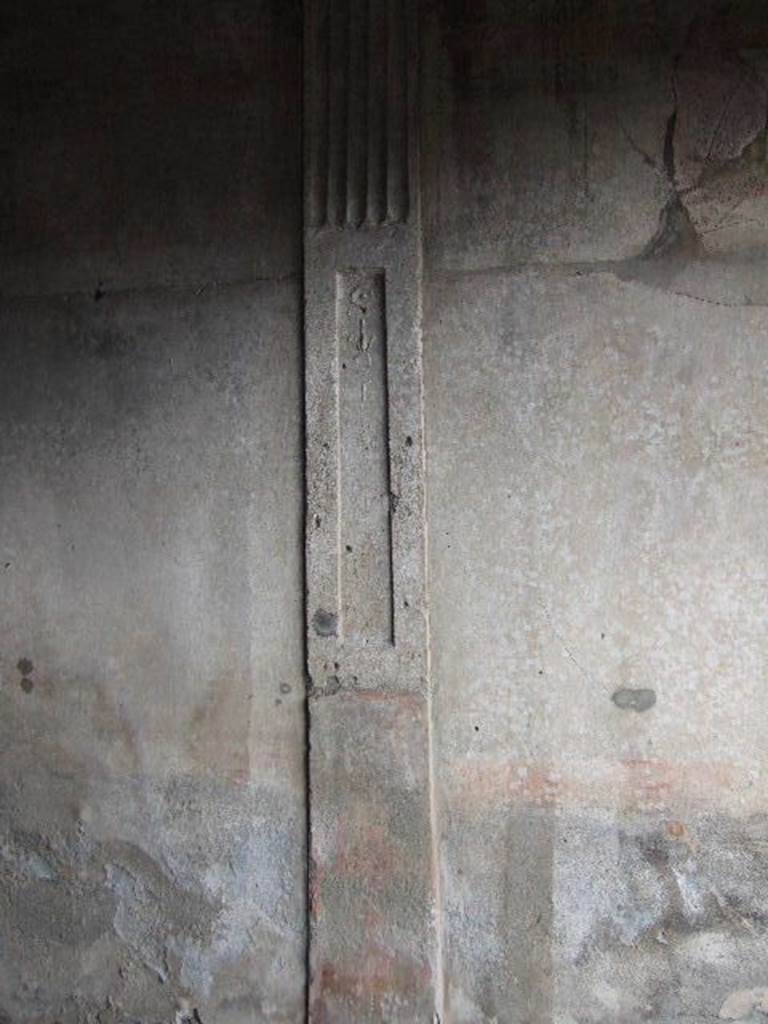 I.6.7 Pompeii. December 2005. East wall of triclinium. On the east wall is a stucco partition in relief, dividing the antechamber and the triclinium. The lower third was painted in red and the part above with a recess which was adorned with floral candelabra with plates.