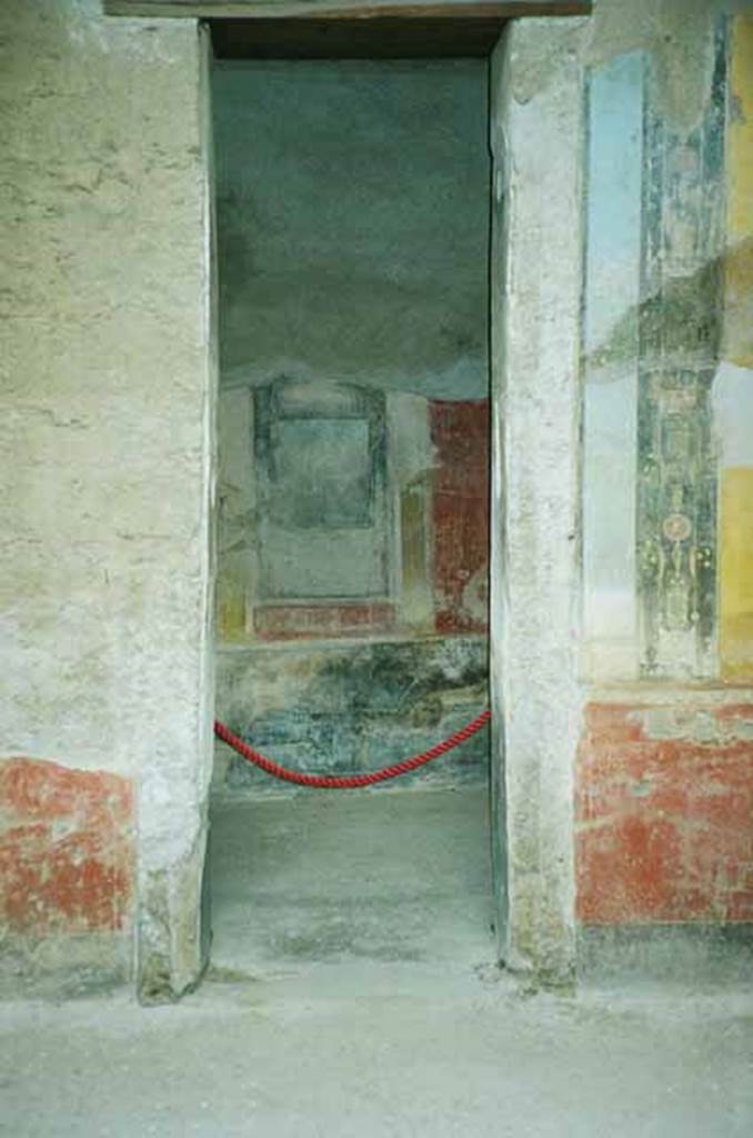 I.6.11 Pompeii. June 2010. Doorway to cubiculum in west wall of atrium. The central aedicula of the west wall was above a black zoccolo and contained a landscape painting on a black background (see Maiuri NS 1929, p.413) which is now unrecognisable. The side panels of all the wall were red and showed metallic pots/vases given to the prize winners of athletic games. Photo courtesy of Rick Bauer.