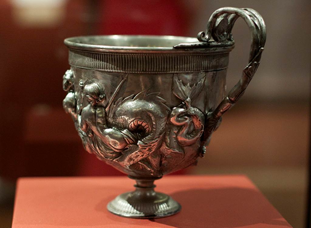 Silver found against west wall of atrium of I.6.11. 
Single handled kantharos or drinking cup decorated with Tritons and Nereid. 
Now in Naples Archaeological Museum.  Inventory number 144802.