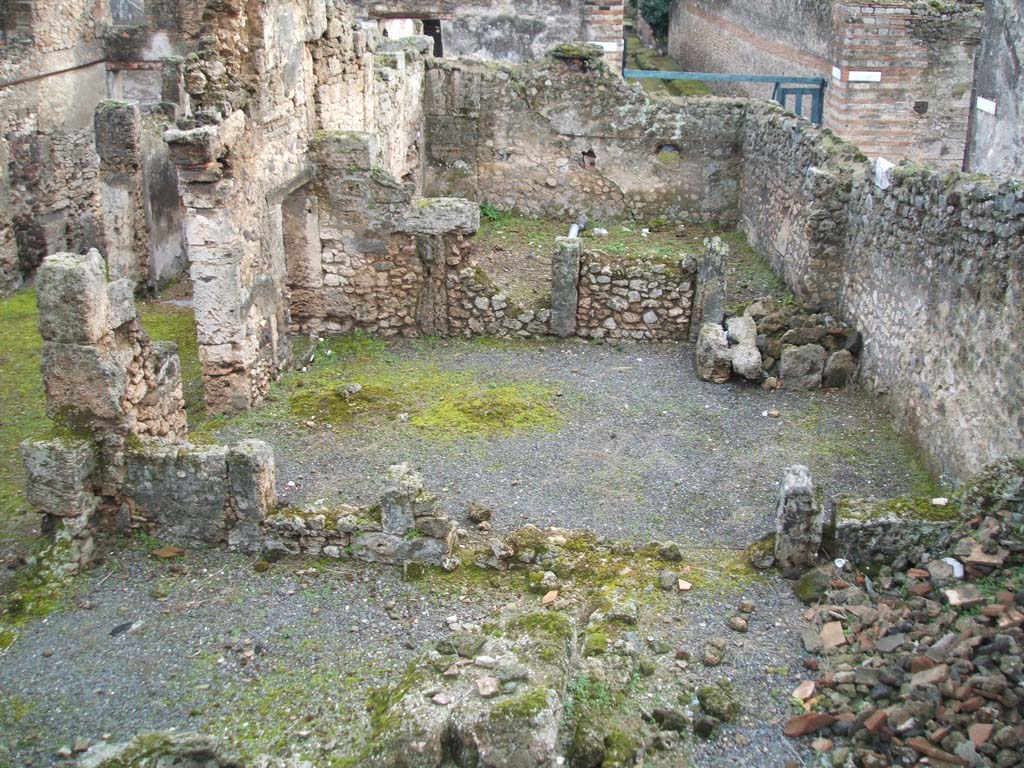 I.6.13 Pompeii. December 2004.  West side looking south, photo taken from rear of I.6.11.
Triclinium 4 would appear to be the large room across the centre of the photo.
Room 7 can be seen on the lower left, room 10 on the lower right.
On the north side of room 10, (but not in the above photo) would have been a small room.
This was described on page 433 of Notizie degli Scavi, 1929, -
“as a second corridor “f” used to separate the narrow rooms 8-9-10 and corresponding to a side doorway to the western vicolo, with a wooden staircase giving access to the upper floor, a doorway that would have been closed or abolished at the time of the abandonment of the house, after the 63 earthquake.”
Room 9 would have been a small room in the north-west corner of the house.