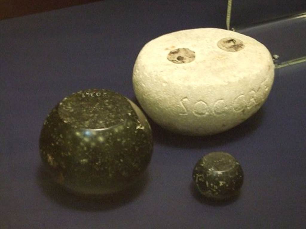 I.6.13 Pompeii. Round white limestone weight.  SAP inventory number 3918.  
The two other black basalt weights were found somewhere in Pompeii, the larger one has SAP 20349 on it. 
Photographed at “A Day in Pompeii” exhibition at Melbourne Museum.  September 2009.