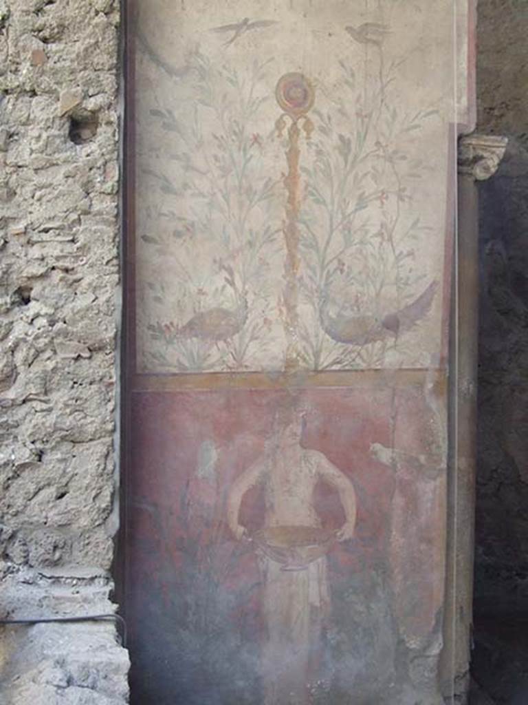 I.6.15 Pompeii. May 2009. Room 9, small garden. 
Wall on west side with painting with birds, plants and a medallion above a figure holding a basin or bowl.