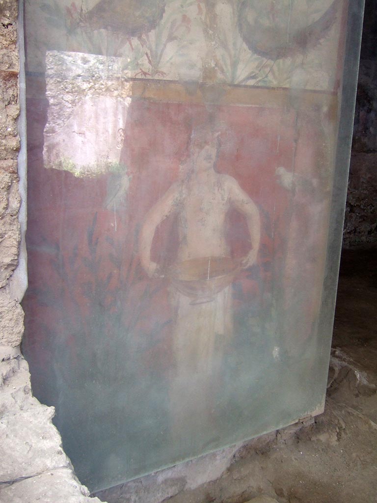 I.6.15 Pompeii. May 2006. 
Room 9, small garden. Wall on west side, painting with birds, plants and a figure holding a basin or bowl.