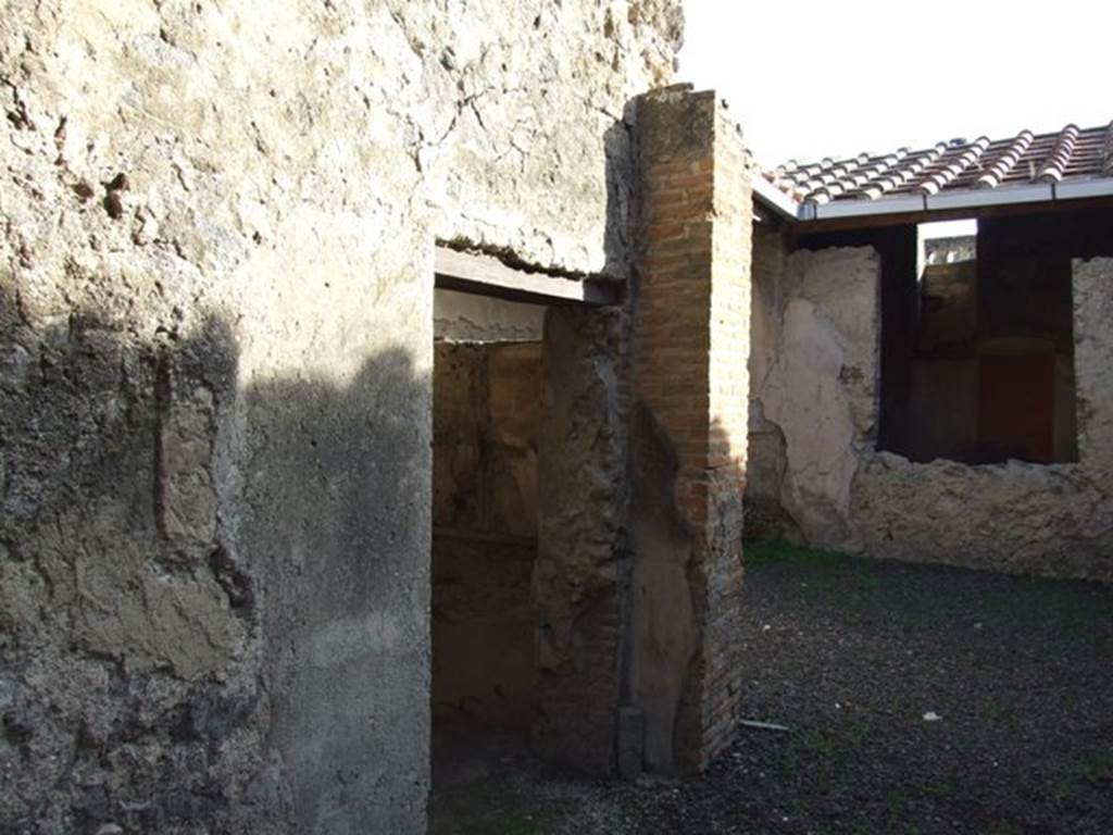 I.7.5 Pompeii. December 2007. East side of vestibule with doorway to cubiculum.  On either side of the vestibule was a pilaster that served as supports for the floor joists of the upper floor. The courtyard and closed tablinum can be seen on the right. On the east side of the courtyard was the kitchen bench, and on the south side were the steps in blocks of Sarno stone.