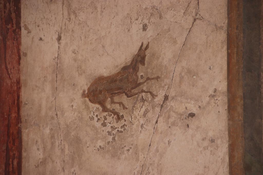 I.7.11 Pompeii. October 2023.  
South wall of exedra at east end, detail of painted decoration in centre of panel. Photo courtesy of Klaus Heese.