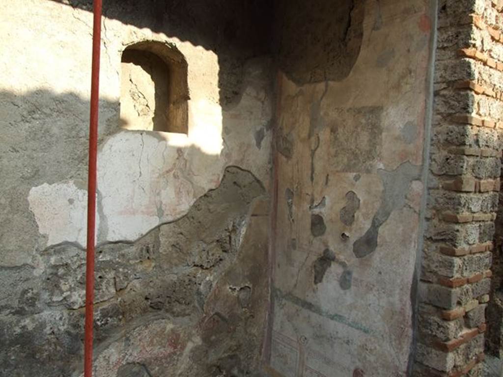 I.7.11 Pompeii. December 2006. Remains of lararium painting with niche set into the wall above it. On the south wall can be seen the remains of a painting.