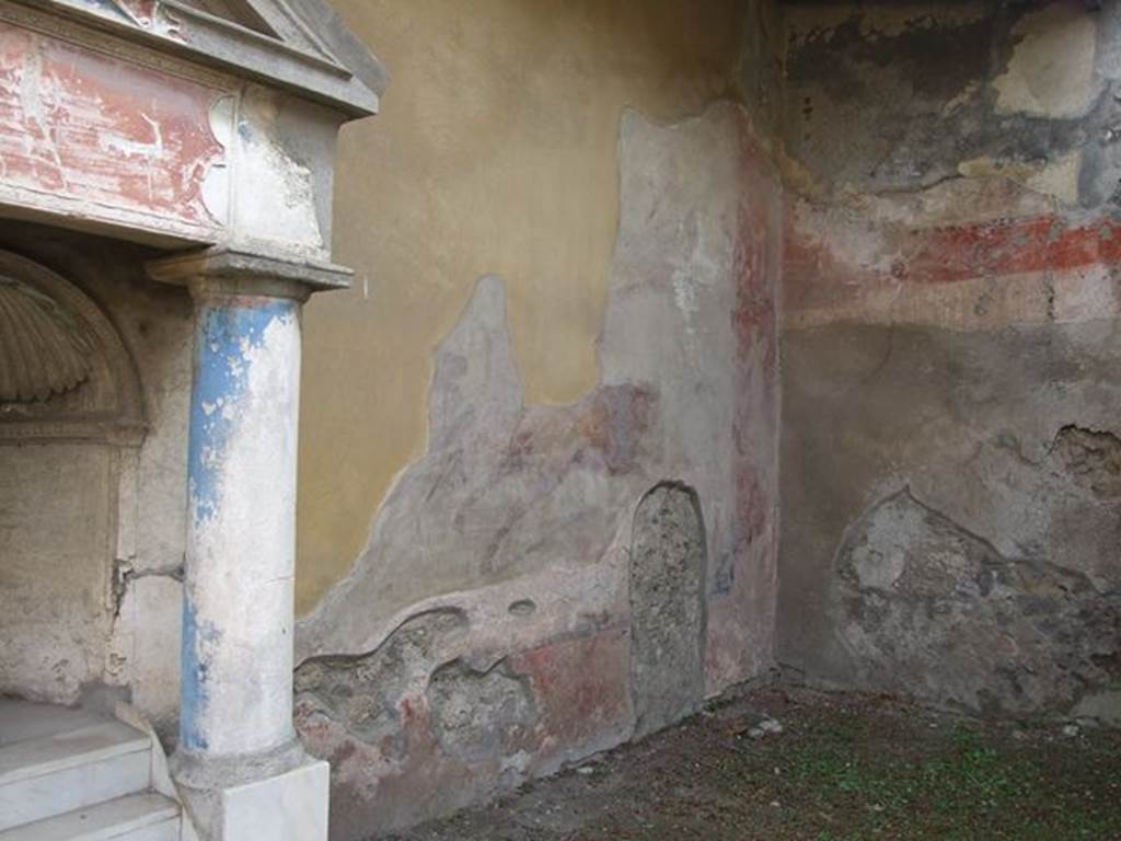 I.7.12 Pompeii. December 2006. 
South-west corner of garden with wall painting of animal scene, on west side of nymphaeum.
On the south wall, below the feet of the lion, the location of a tunnel can be seen (now blocked), dug by the ancient searchers.