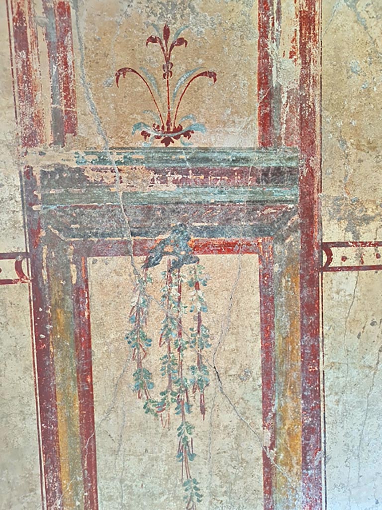 I.7.12 Pompeii. March 2024. 
Detail of painted decoration on east side of doorway in north wall. Photo courtesy of Giuseppe Ciaramella.