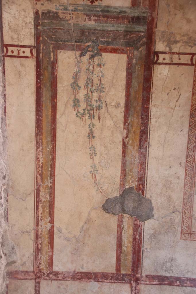 I.7.12 Pompeii. September 2021. 
Detail of painted decoration on east side of doorway in north wall. Photo courtesy of Klaus Heese.
