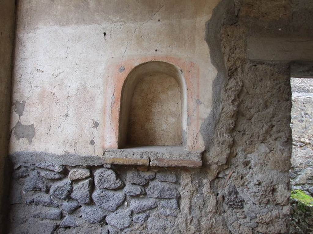 I.7.19 Pompeii. December 2006. Niche in west wall of north portico.
According to Boyce, this arched niche had a simple aedicula façade painted in red on the wall around it. Beside the niche was the faded figure of a boar done in red monochrome and on the wall below it were traces of a still older decoration. Boyce says in note 4 on page 26, that the figure of the boar and the older decoratoion had no connection with the lararium. Not. Scavi, 1929, 370. See Boyce G. K., 1937. Corpus of the Lararia of Pompeii. Rome: MAAR 14. (p.26, no.43)