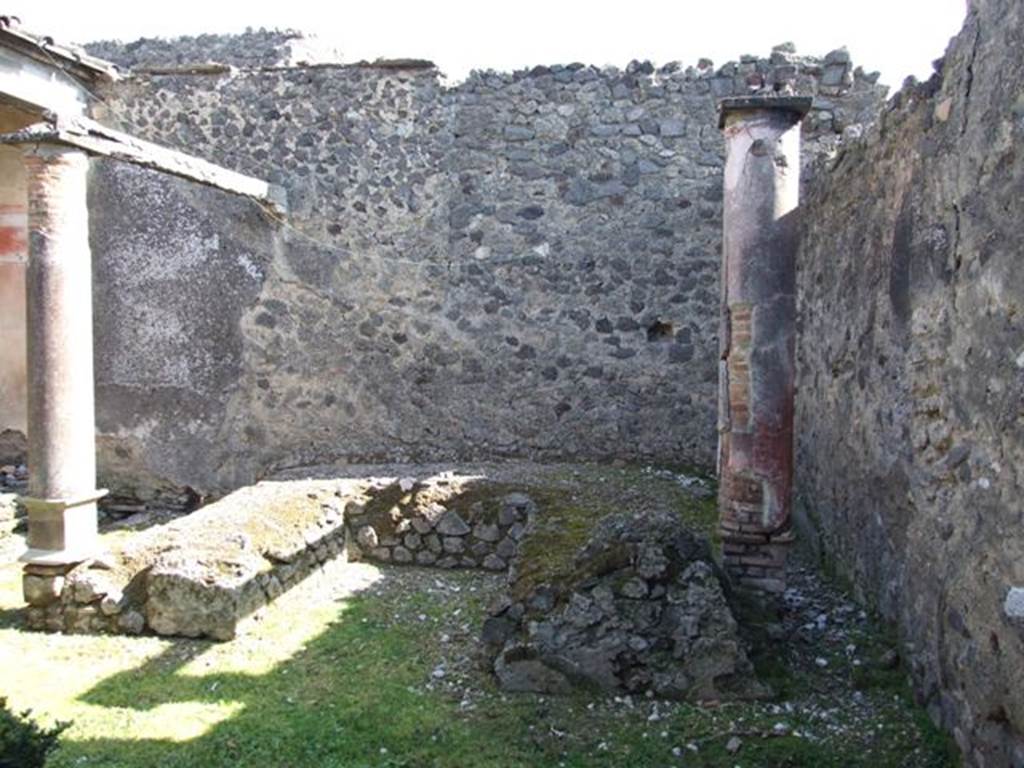 I.8.9 Pompeii.  March 2009.  Room 9 and Garden area.  Triclinium against east wall with two red painted columns built on the couches.
These columns supported a pergola above the triclinium.